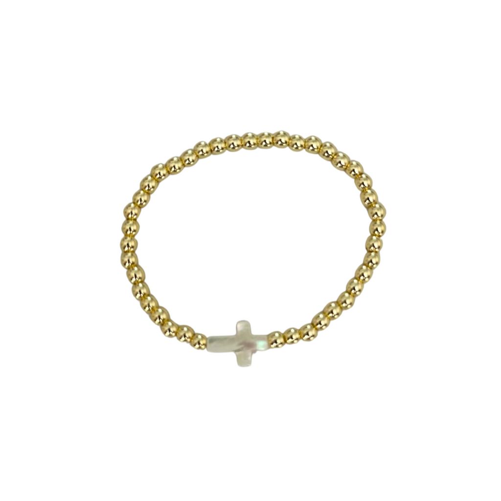 Gold bracelet with a small cross charm on a white background